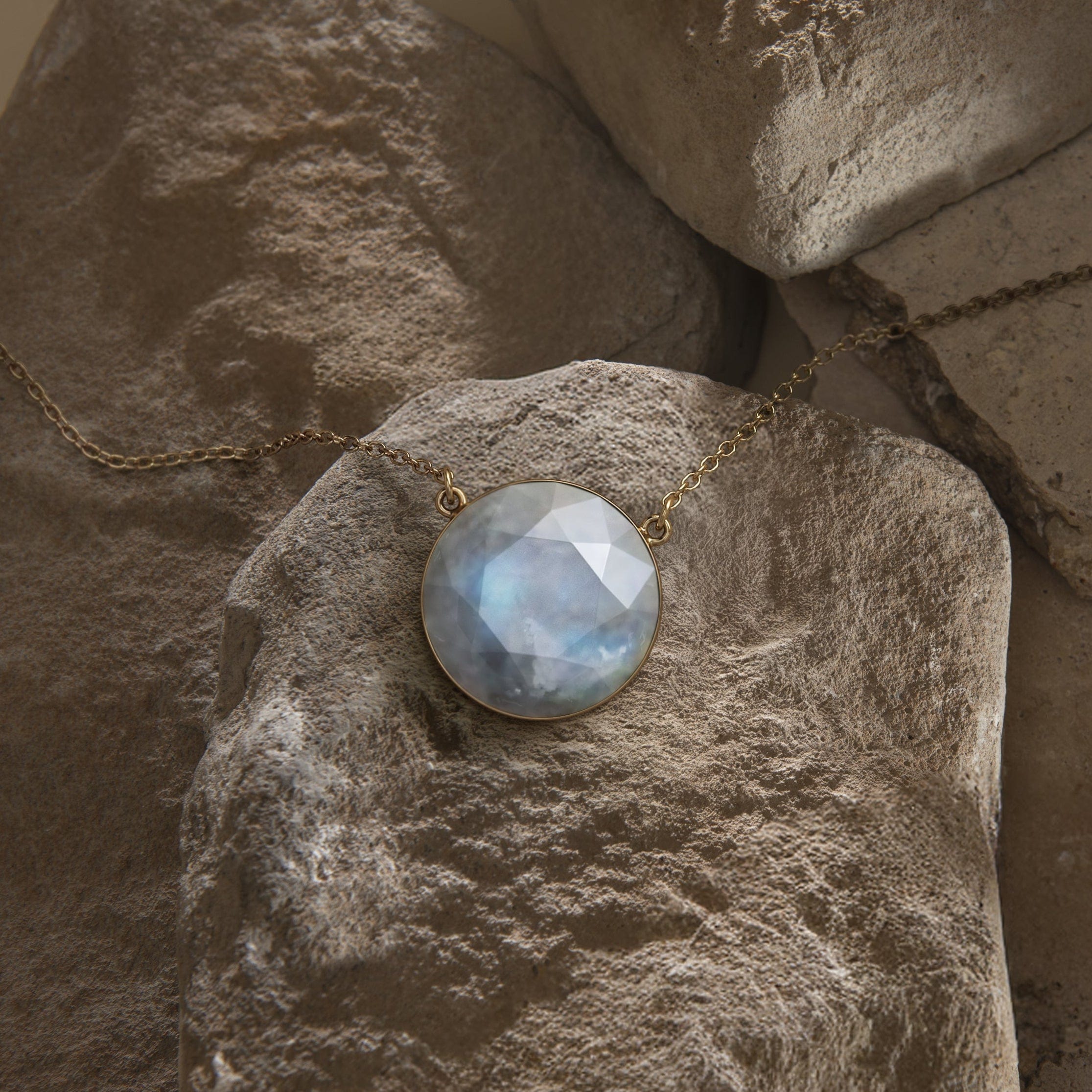 Daya moonstone necklace resting on natural stone